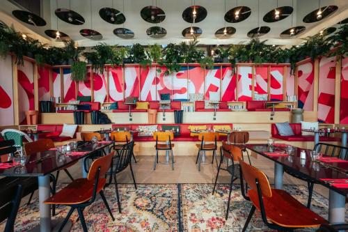 a restaurant with tables and chairs in a room at JOST Hotel Montpellier Centre St Roch in Montpellier