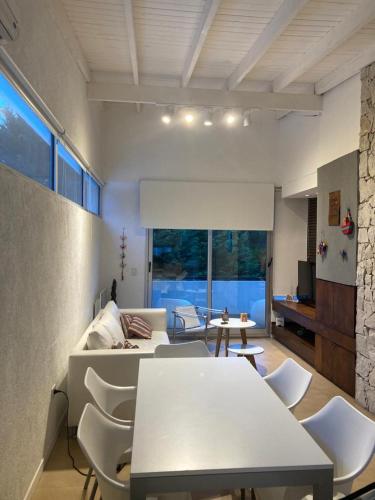 a living room with a table and chairs and a couch at Punta vacaciones -piscina solo en vacaciones y fines de semana largos- in Las Gaviotas
