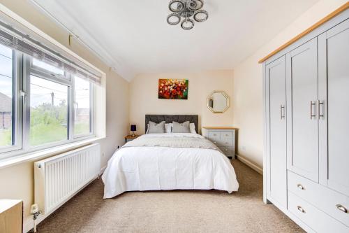 um quarto com uma cama e uma janela em London serviced apartments BAFOG em Barking