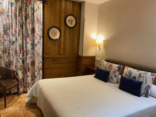 a bedroom with a bed and two clocks on the wall at La Casona de Pío in Cudillero