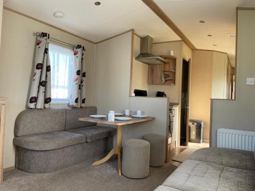 a living room with a table and a couch at 8 Berth family caravan Selsey West Sussex in Selsey