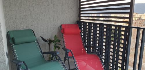 three colorful chairs sitting on a balcony at Love Journey Tbilisi in Tbilisi City