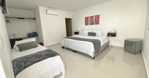 a hotel room with two beds in a room at Hotel El Marqués De Manga in Cartagena de Indias