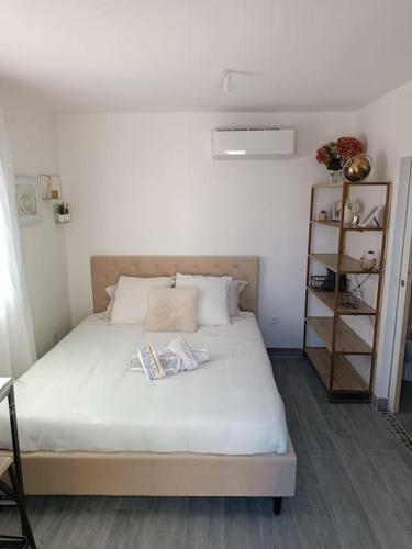a bedroom with a white bed with a book shelf at Charmant studio avec piscine in Villemoustaussou