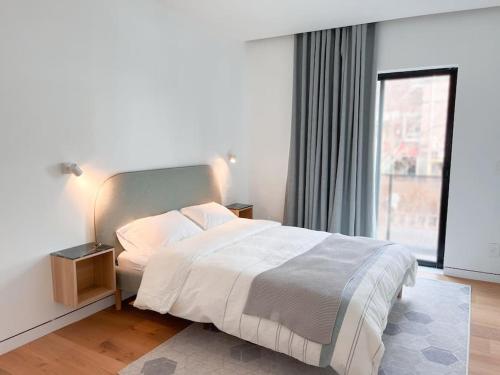 a bedroom with a bed and a large window at New Ample and Cozy One Bedroom Apt in Brooklyn at Rem-Casa in Brooklyn