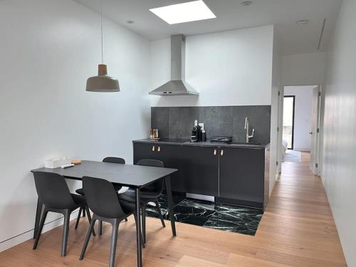 ブルックリンにあるNew Ample and Cozy One Bedroom Apt in Brooklyn at Rem-Casaのテーブルと椅子のあるキッチンとダイニングルーム
