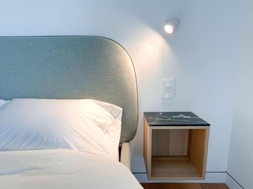 ブルックリンにあるNew Ample and Cozy One Bedroom Apt in Brooklyn at Rem-Casaのベッドルーム1室(ベッド1台、ナイトスタンド、白い枕付)