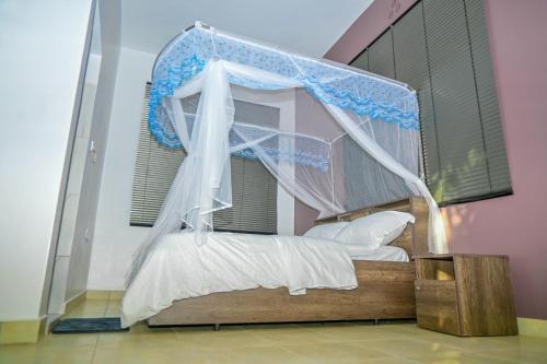 a bed with a canopy in a pink bedroom at Shali Hotel in Wote