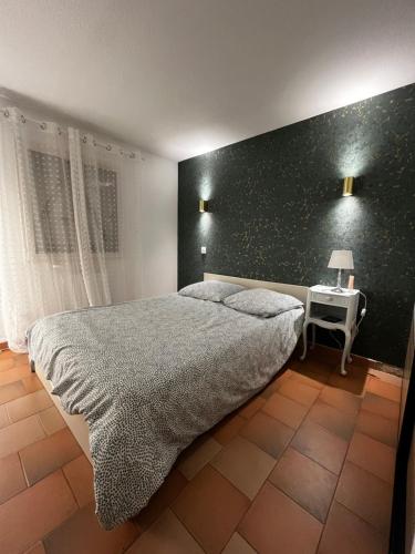 - une chambre avec un grand lit et une table de chevet dans l'établissement Bel Appartement au coeur de la Marina Port Cogolin, à Cogolin