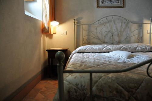 a bedroom with a bed with a metal headboard at Agriturismo Il Macchione in Pienza
