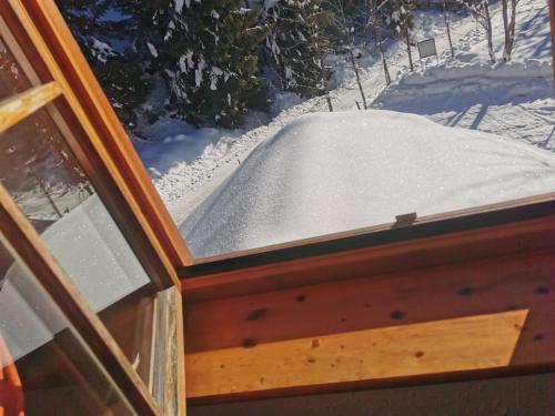 a window with a pile of snow outside of it at POHORJE HOUSE 2 FOUR APPARTMETNS in Oplotnica