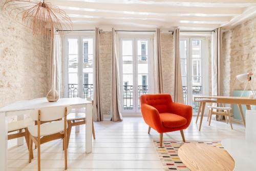 un salon avec une chaise rouge et une table dans l'établissement Santorini, à Paris