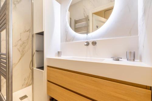 une salle de bain avec un lavabo et un miroir dans l'établissement Santorini, à Paris