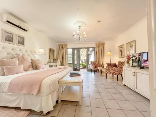 a bedroom with a large bed and a living room at Amoris Guesthouse In Waterkloof Ridge in Pretoria