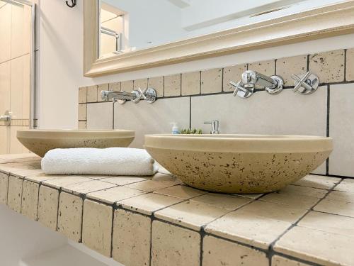 a bathroom with two sinks on a tiled counter at Amoris Guesthouse In Waterkloof Ridge in Pretoria