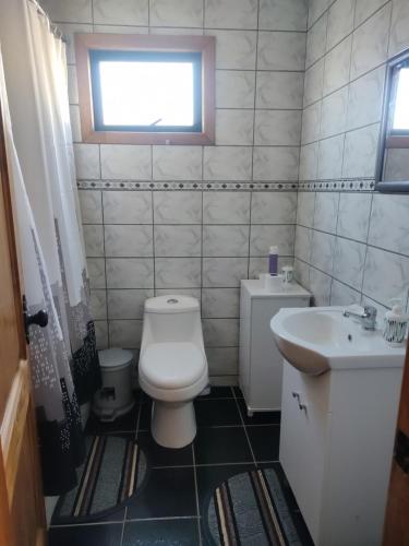 Baño pequeño con aseo y lavamanos en Cabañas Vera, en Punta Arenas