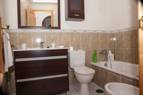 uma casa de banho com um WC, um lavatório e uma banheira em Apartamento junto al mar en Torrox Costa em Málaga