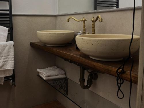 a bathroom with two sinks on a wooden counter at Le Arcate del Giglio - Luxury Suite in Sansepolcro