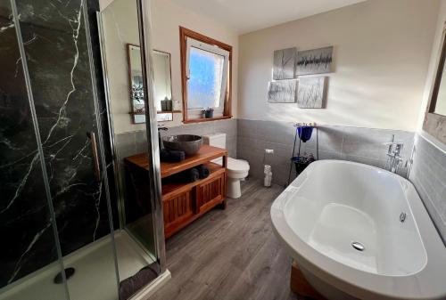 a bathroom with a tub and a shower and a toilet at SEAcroft Licensed B&B and Restaurant in Aird Uig