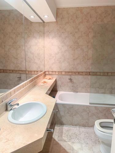 ein Badezimmer mit einem Waschbecken, einer Badewanne und einem WC in der Unterkunft Departamento céntrico y moderno in Río Cuarto