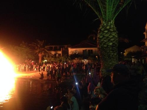 a crowd of people standing around a palm tree at night at Jerkovic Apartment in Žuljana