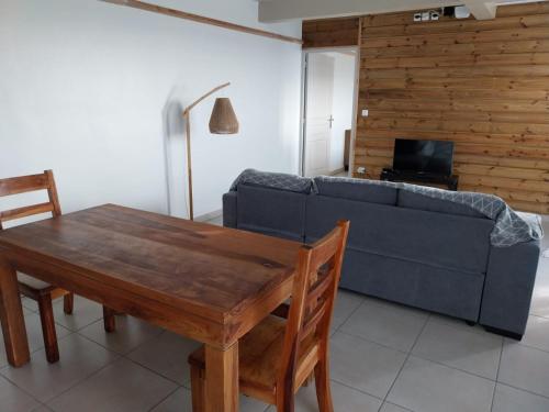 ein Wohnzimmer mit einem blauen Sofa und einem Holztisch in der Unterkunft VILLA MARIE in Marigot