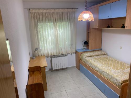 um pequeno quarto com 2 camas e uma janela em El enebrón - Hoces del río Duratón 