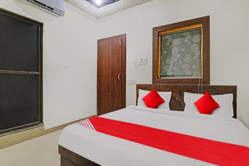 sypialnia z dużym łóżkiem z czerwonymi poduszkami w obiekcie OYO Flagship R V Palce w mieście Gorakhpur