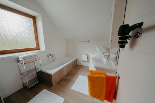 a bathroom with a sink and a tub and a sink at Ferienhäuser Inge und Seeblick in Oberaichwald