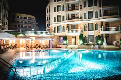 a swimming pool in front of a building at night at Apart Hotel Apolonia Palace in Sinemorets
