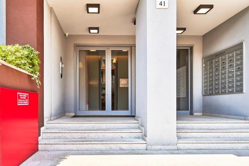 eine Fassade eines Gebäudes mit einer roten Tür in der Unterkunft Monviso Mono - Exclusive Apartment in Mailand