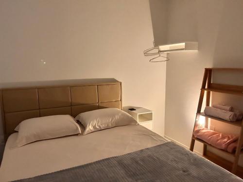 um quarto com uma cama com duas almofadas em Apto térreo com garagem coberta em Tijucas