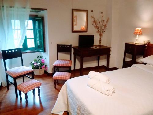 a bedroom with a bed and a desk and chairs at Casa Pacios by M de Santiago in Tríacastela