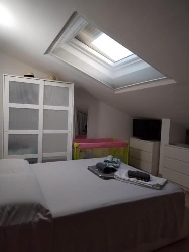 a bedroom with a large bed with a skylight at Sweet Home Airport Fiumicino in Fiumicino