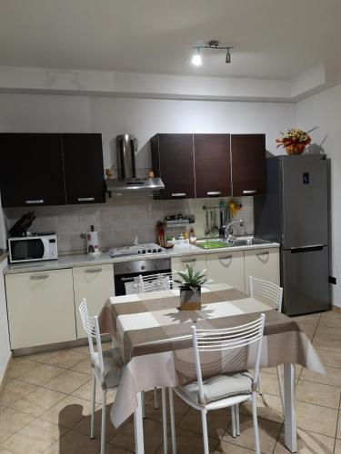 a kitchen with a table and a kitchen with a refrigerator at Sweet Home Airport Fiumicino in Fiumicino