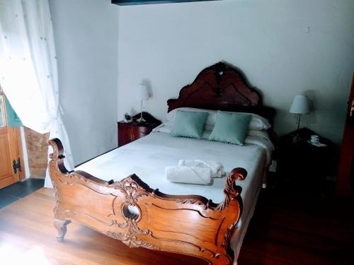a bedroom with a wooden bed in a room at Casa Pacios by M de Santiago in Tríacastela