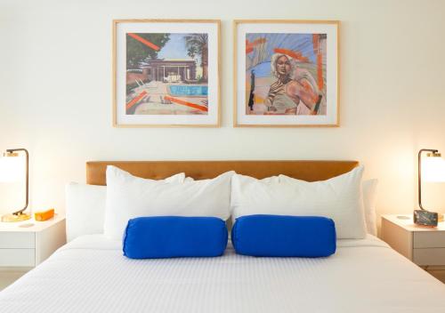 a bedroom with a bed with two pictures on the wall at Little Mod Hotel at the University in Charlottesville