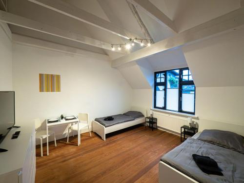 Schlafzimmer mit einem Bett, einem Schreibtisch und einem Fenster in der Unterkunft Work & Stay Apartment near Hamburg in Ahrensburg