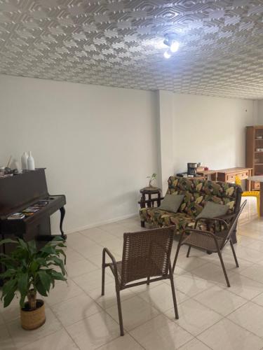 uma sala de estar com um sofá e um piano em Pousada Vivera em Jaraguá do Sul