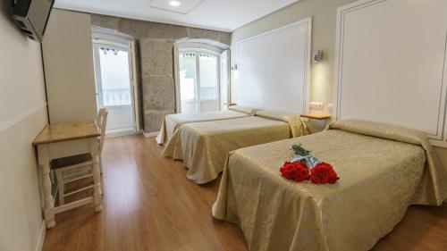 um quarto de hotel com duas camas e uma mesa com morangos em Hostal Madrid em Madri
