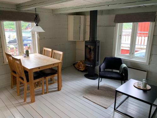 a living room with a table and a wood stove at Vesterålen Rorbuer in Bø i Vesterålen