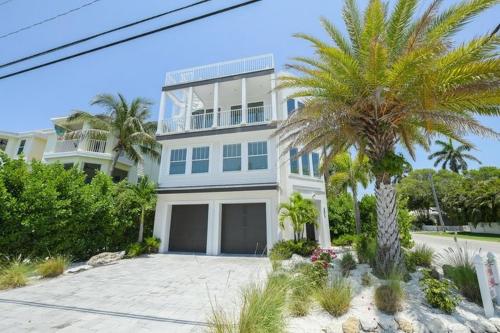een groot wit huis met een palmboom ervoor bij 2201 AVE C home in Bradenton Beach