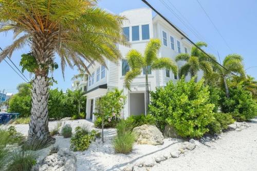 een wit huis met palmbomen ervoor bij 2201 AVE C home in Bradenton Beach