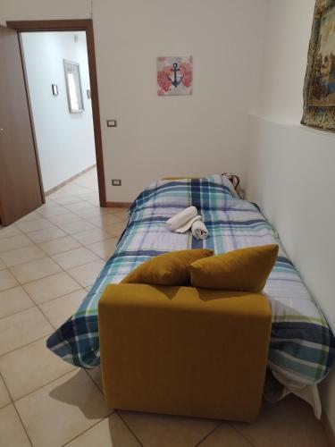 un letto con un divano giallo in una camera di Casetta Malfitano a Palermo