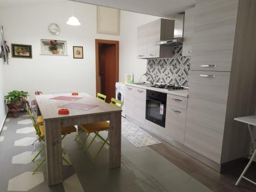 una cucina con tavolo in legno e una sala da pranzo di Casetta Malfitano a Palermo