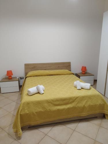 una camera da letto con un letto giallo e asciugamani di Casetta Malfitano a Palermo