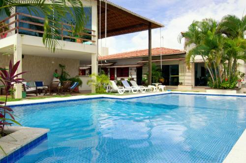 a swimming pool in front of a house at Pousada Novo Prado in Prado