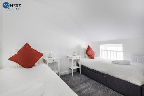 Duas camas num quarto com almofadas brancas e vermelhas em Bright 2bed Apartment in Worksop em Worksop