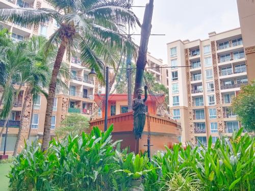 a statue hanging from a palm tree in a city at Atlantis Condo Resort in Jomtien Beach