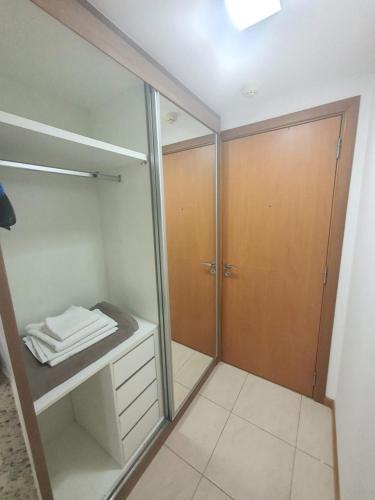 a bathroom with a walk in shower and a closet at Flat Saint Moritz Express By Rei dos Flats in Brasilia